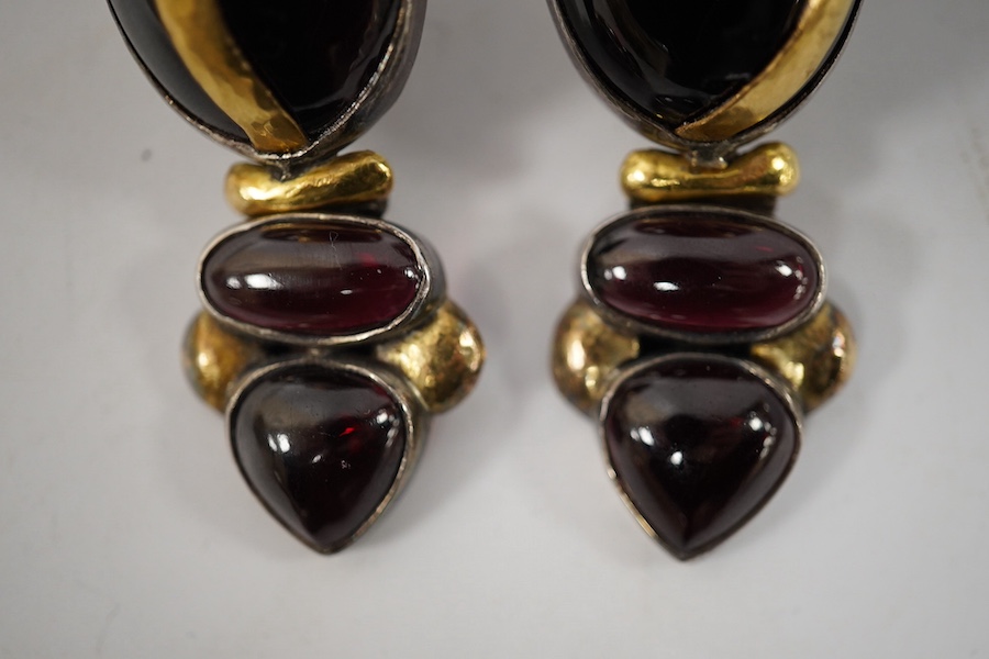 A pair of modern yellow and white metal mounted three stone oval cabochon garnet set drop earrings, by Elaine Coyne, signed, 51mm, gross weight 28.2 grams. Condition - fair